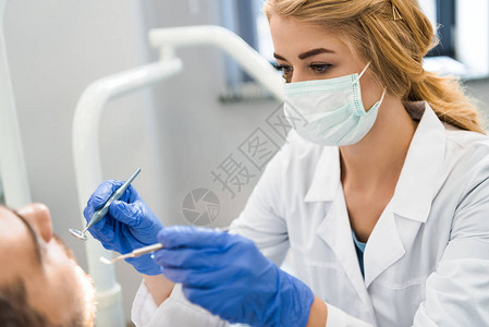检查客户牙齿的年轻女牙医背景图片