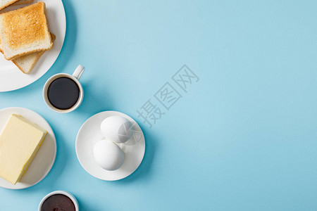 新鲜鸡蛋果酱黄油咖啡和两张蓝色底白背景图片