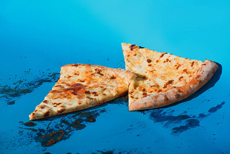 蓝色背景下熟披萨的特写视图背景图片