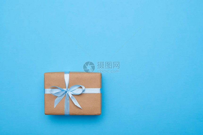 平整的浪漫礼物包着装饰在蓝色背景和复制图片