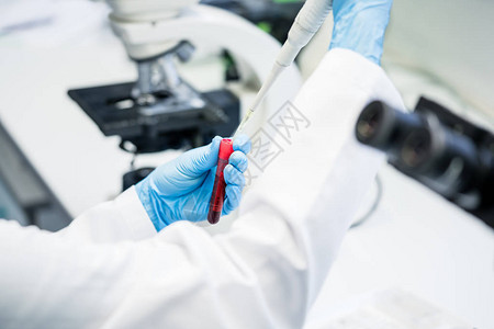 实验室助理将溶液放入实验室进行血液测试图片