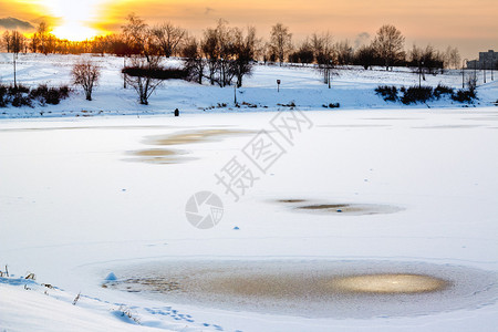 日落时独自在池塘上冰钓的人图片