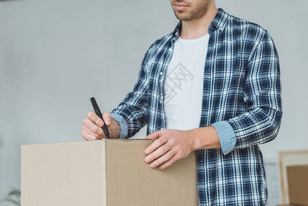 男子签名纸板箱搬家的短片搬迁概念背景图片