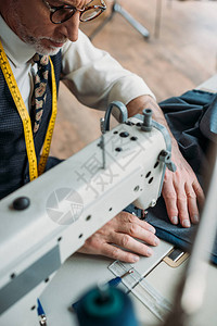 在缝纫车间用缝纫机缝纫机的英俊专业裁缝纫布图片