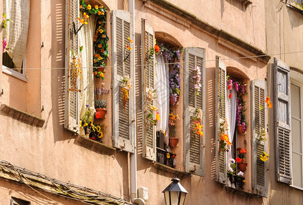 装饰多彩假花的窗户和百叶窗图片