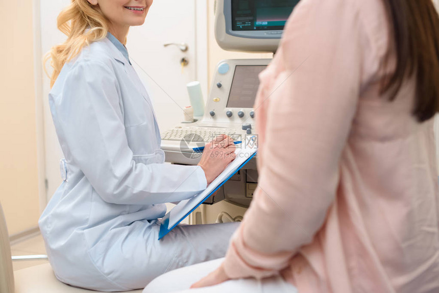 产科妇医生在超声波扫描办公室为孕妇提供咨询的一针图片