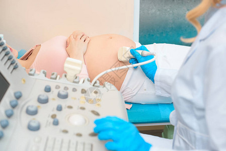 产科妇产科医生对孕妇进行超声波检查的人工背景图片