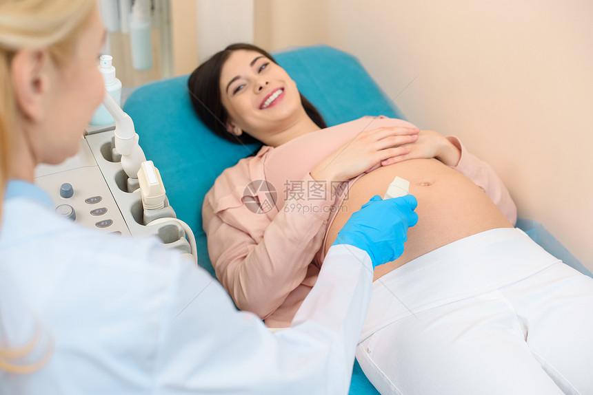妇产科医生为年轻孕妇进行超声检查图片