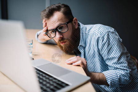 沮丧疲劳的压力沮丧的商人使用笔记本电脑和互联网坐在阁楼办公室图片