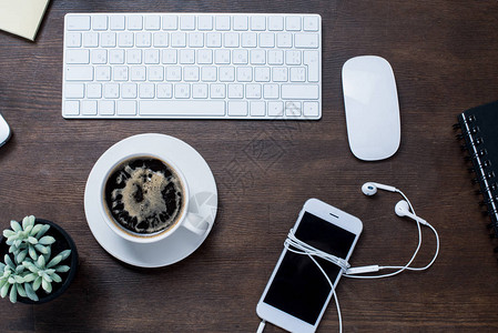 咖啡杯带耳机的智能手机计算机鼠标和键盘办公桌锅图片