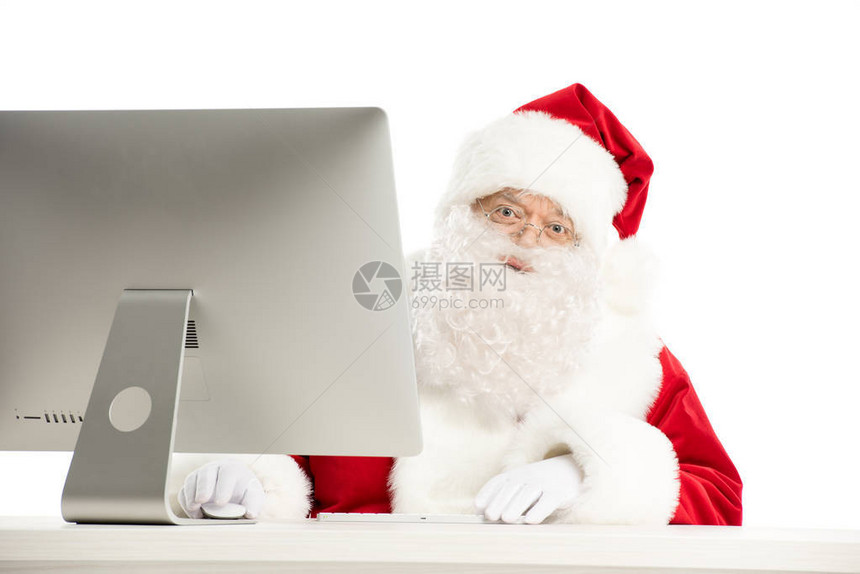 圣诞老人的肖像在用电脑坐在桌子上图片