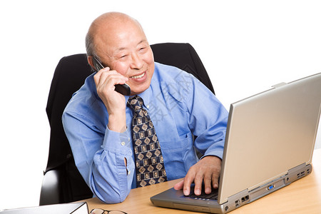 一名高级亚洲商人在笔记本电脑上工作时图片