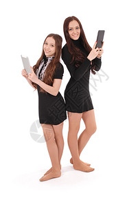 两个女孩把平板电脑放在白色的图片