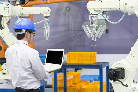 机械工程师在制造工厂控制机器人手臂工业40概念图片