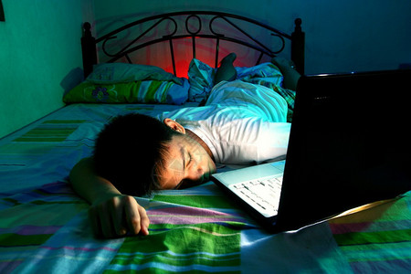 液晶屏素材一张年轻青少年睡在笔记本电脑前背景
