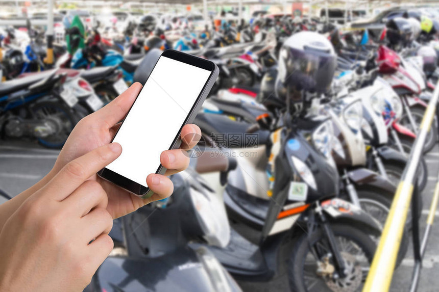 人手拿着智能手机平板电脑手机在模糊的停车摩托车上在线跟图片