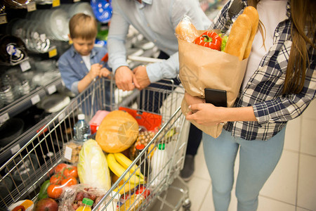 快乐的年轻家庭与儿童在超市购物一起微笑图片