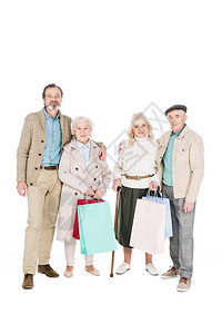 快乐的退休朋友拿着购物袋站着图片