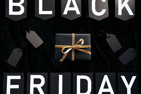 黑色周五信件包裹的礼品和黑色背景上的空白价格图片