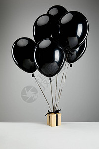 黑色的黑气球和礼物盒隔离在灰色黑色图片