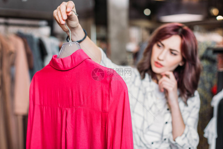 在购物商场选择服装的年轻沉浸在童年的时装女孩图片