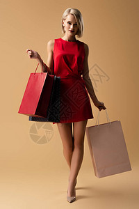 穿着红色礼服拿着购物袋的美丽年图片