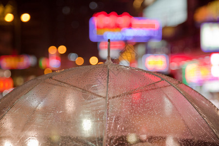 透明雨伞和城市灯光图片