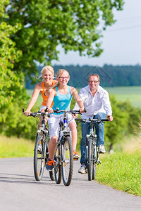父母和女儿在车道上骑自行车图片