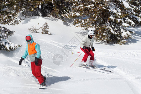 滑雪者和单板滑雪者骑在雪山上的滑雪胜地图片