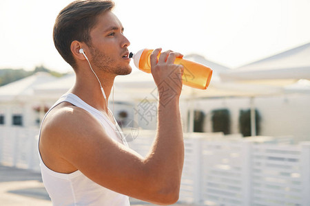 体育概念男子在锻炼后喝水口渴的健康男与健康的身体喝清凉饮料跑步或户外训练背景图片