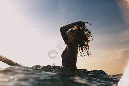坐在海洋冲浪板上重修头发的背景图片