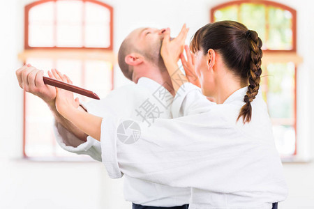 在武术学校Aikido训练中用木刀打架图片