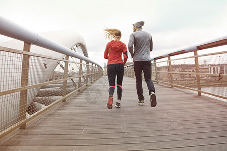 健身夫妇早上一起在户外慢跑图片