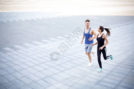 快乐运动的年轻男女青年在城市里奔跑图片