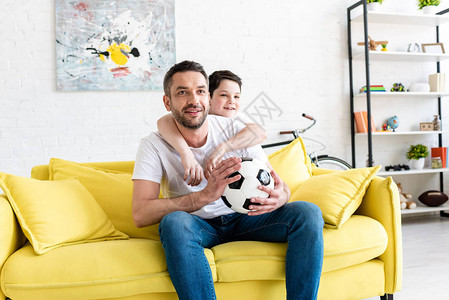 父亲和儿子在沙发上看体育比赛图片