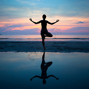 瑜伽健康和谐日落时沙滩上图片