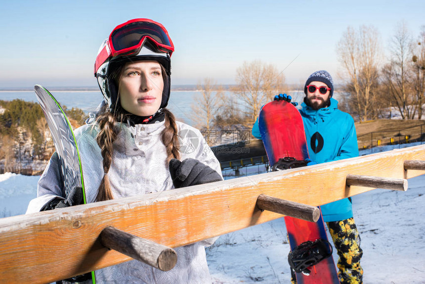 滑雪度假胜地的年轻男女滑雪运动员拿着图片