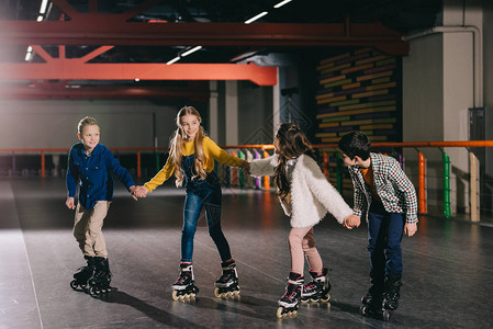 微笑的孩子们在溜冰场上溜冰手牵图片