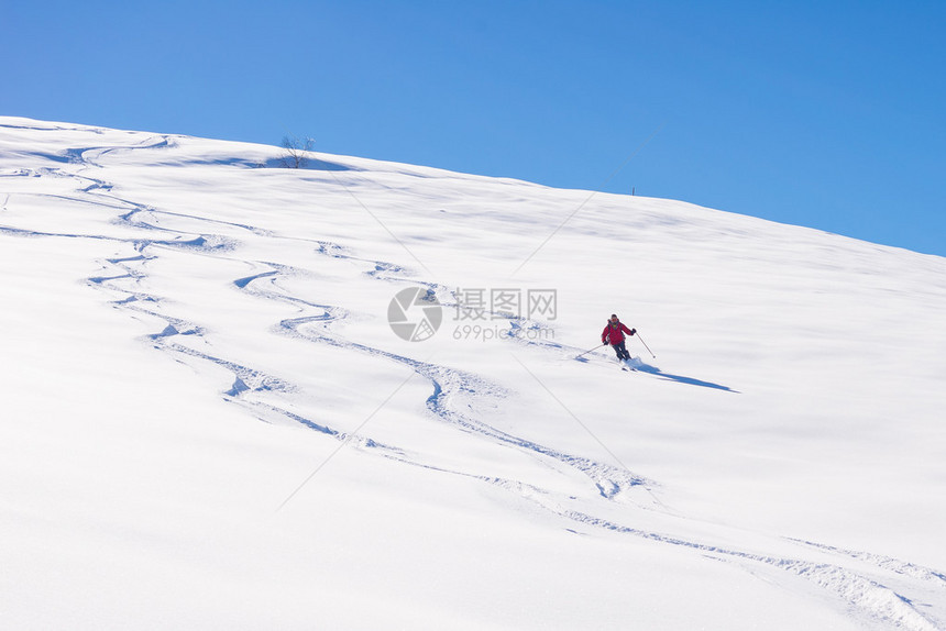 一个人在意大利阿尔卑斯山的雪坡上滑下脚踏板图片