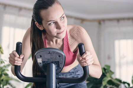 欧洲妇女在家里就运动自行车进行心操锻炼培训图片