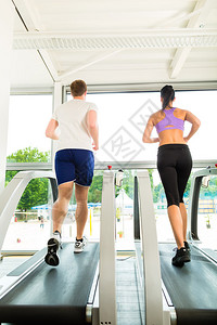 在健身房或健身俱乐部的跑步机上跑步图片