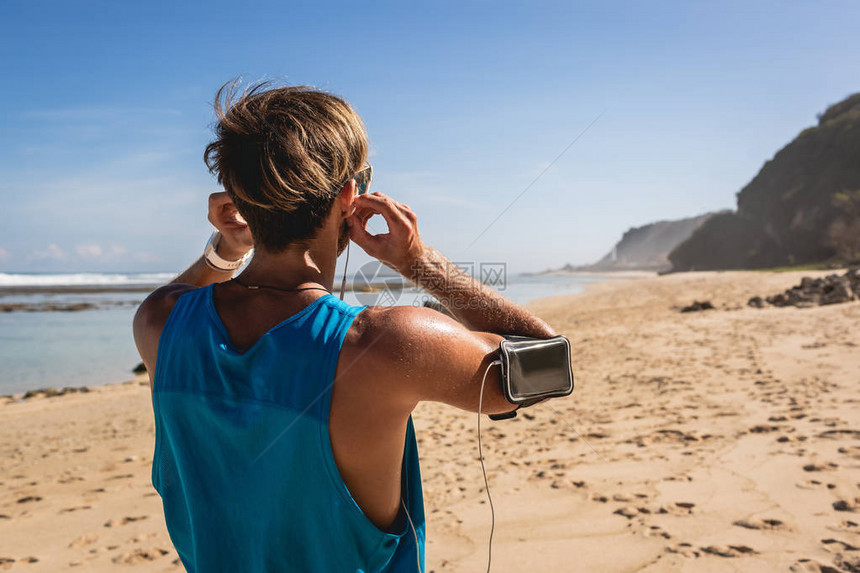 印度尼西亚巴厘岛海滨臂章运动员用耳机和智图片