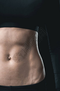 女人的肌肉发达腹肌被黑色隔开运动概念图片