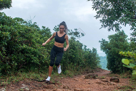 夏季在山区森林小路上跑步的健身女运动员锻炼上坡图片