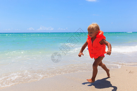 在夏日海滩穿救生衣的可爱小女图片