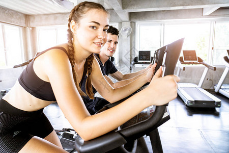 健身女人在健身房锻炼自行车健身和健康的生活方式h机器有氧图片