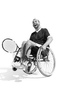 坐在轮椅上的快乐残疾网球运动员的白和黑色照片背景图片
