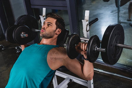 肌肉发达的运动型男子在健身房用哑铃锻炼图片