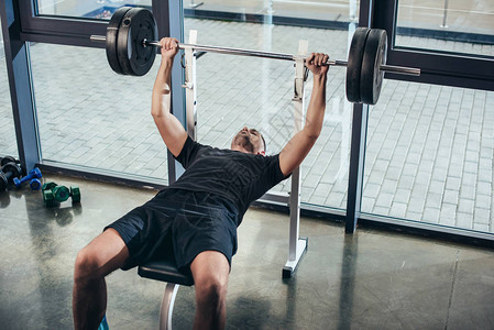 健壮的体育男子在健身房坐长椅时图片