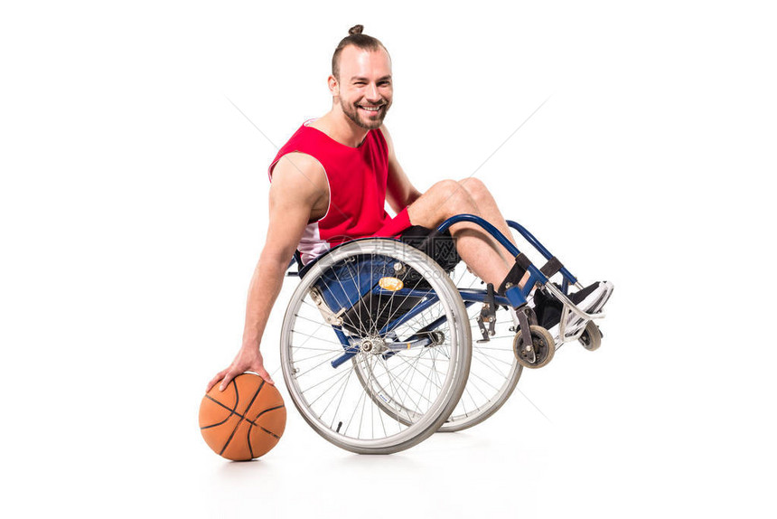 坐在轮椅上玩篮球的年轻运动员微笑着图片